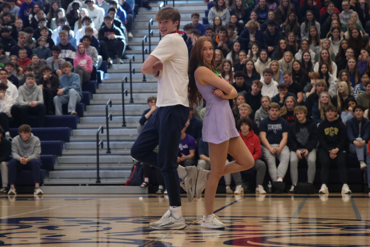 Standing back to back, seniors Carter Kaifes and AnnMarie Geise strike a pose after their candidate handshake.