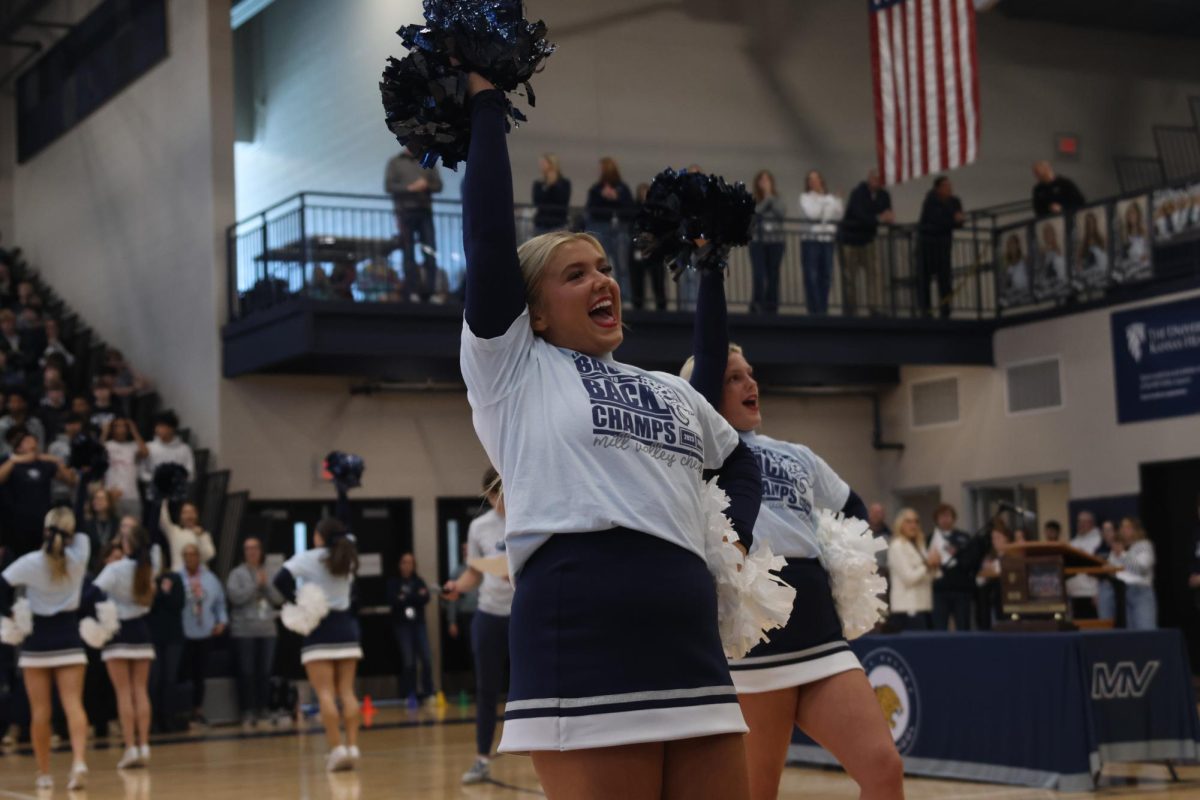 Raising her pom in the air, senior Maddie Dibble gets the crowd excited before the assembly.