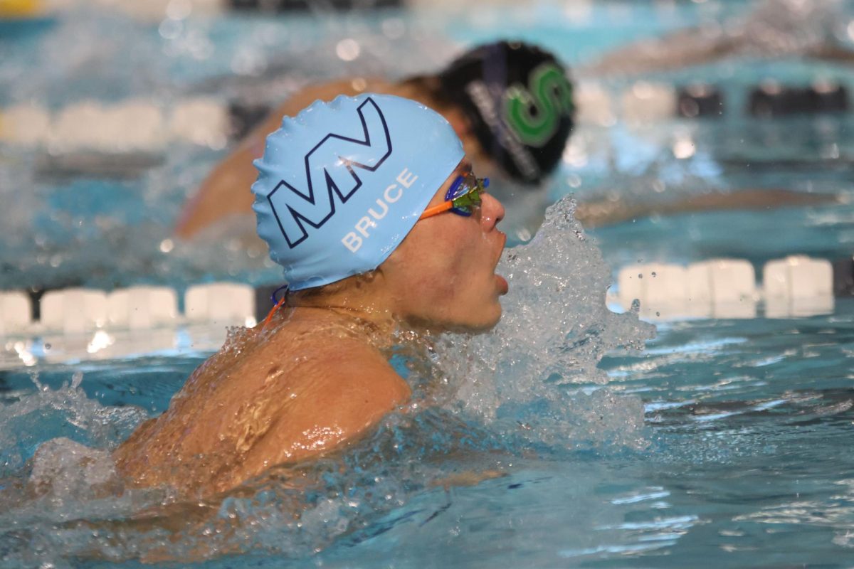 Taking a breath for air, sophomore Turner Bruce finishes his 100 meter breaststroke.
