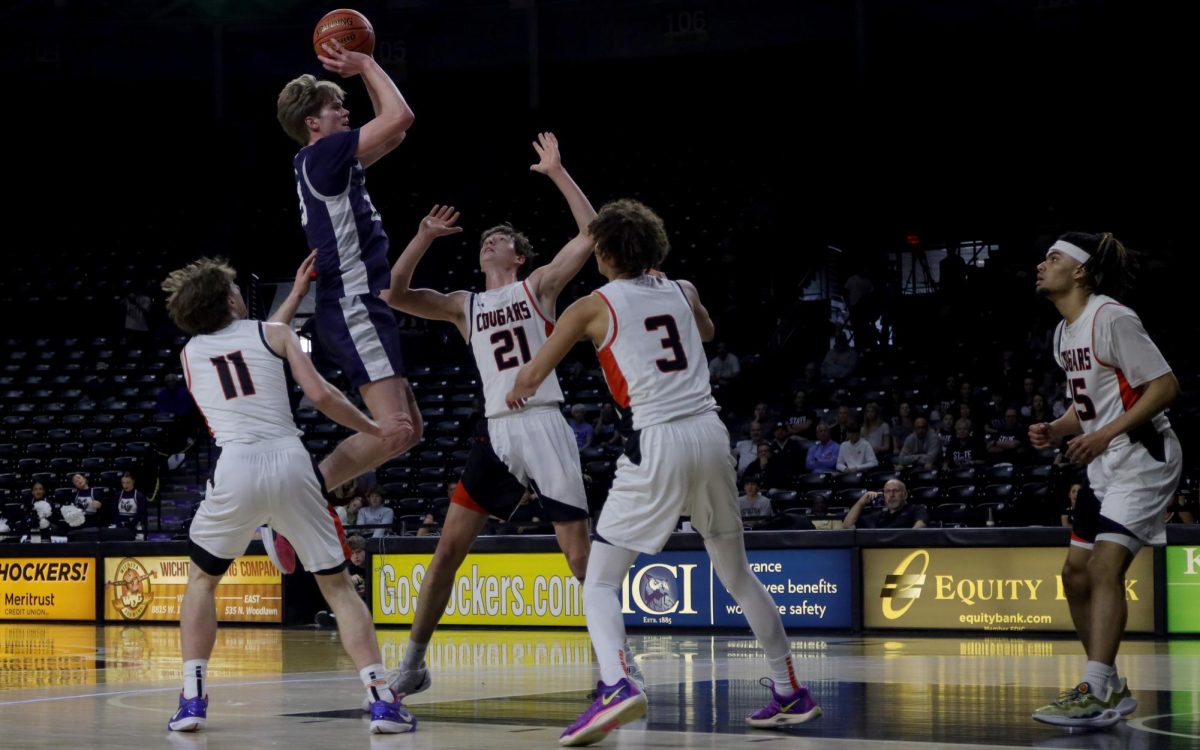 Over the defenders, senior Carter Kaifes shoots the ball.