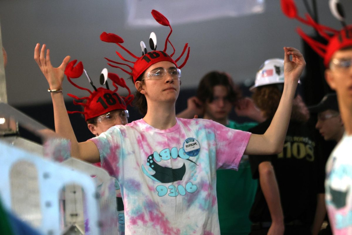 With his hands in claws, junior Ethan Culver looks to the crowd while his team is announced.