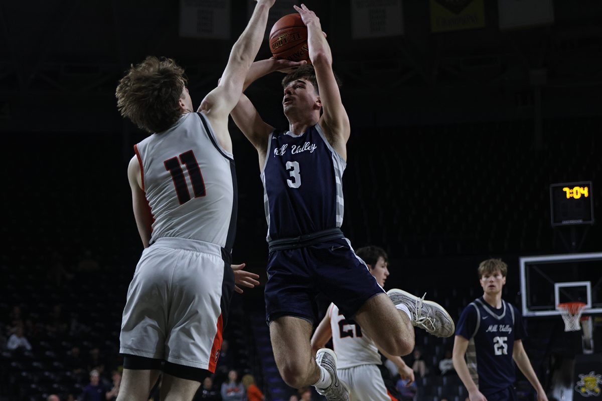 Avoiding the defender, senior Thatcher Ivey looks to shoot the ball.