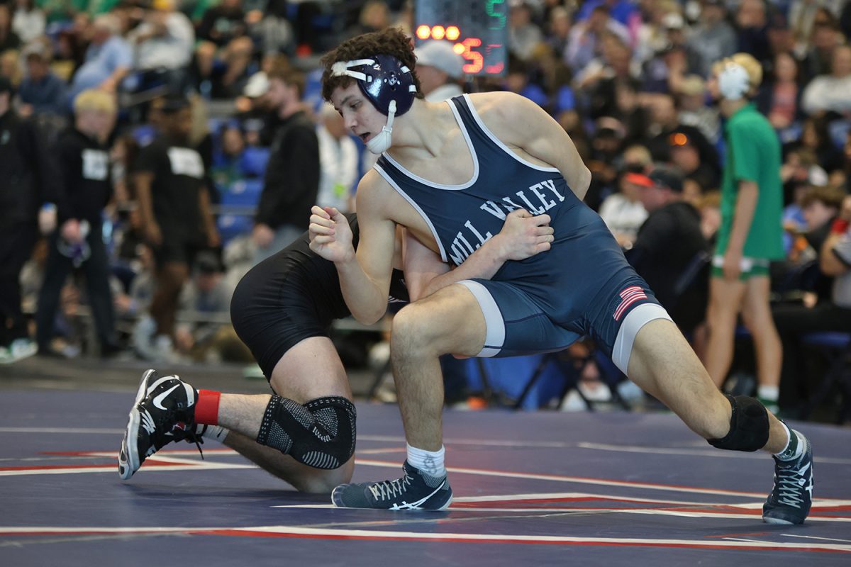 With a quick step, sophomore Luke Whisler breaks away from the other wrestler's arms.