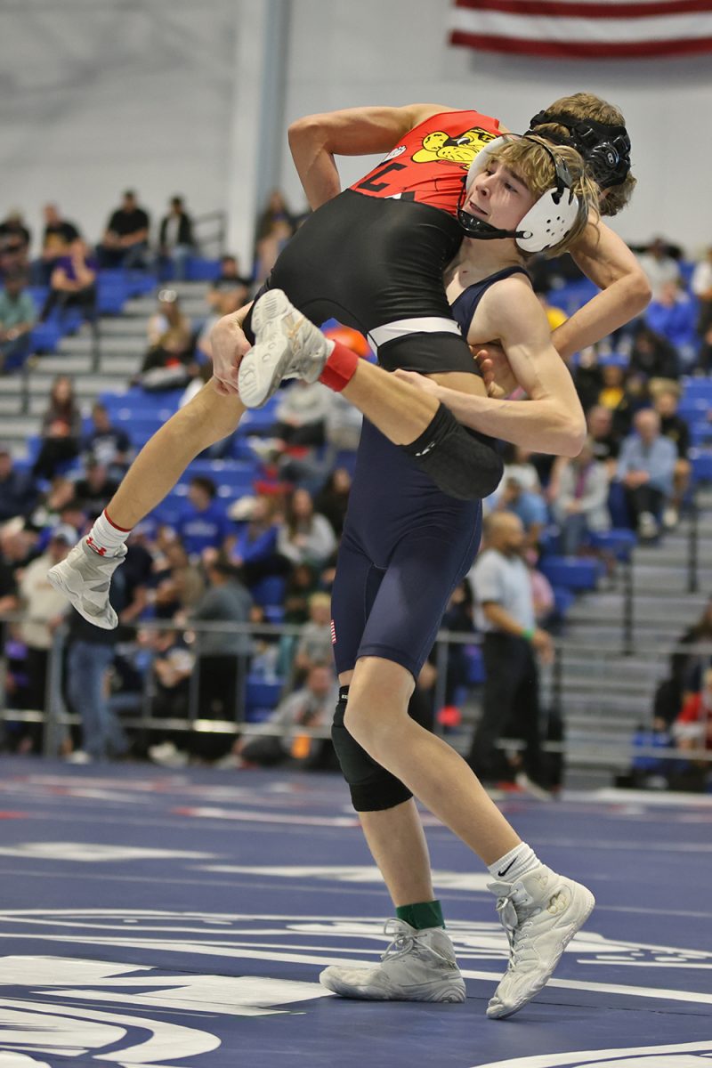 Taking a step, freshman Charlie Supica lifts the other wrestler into the air.