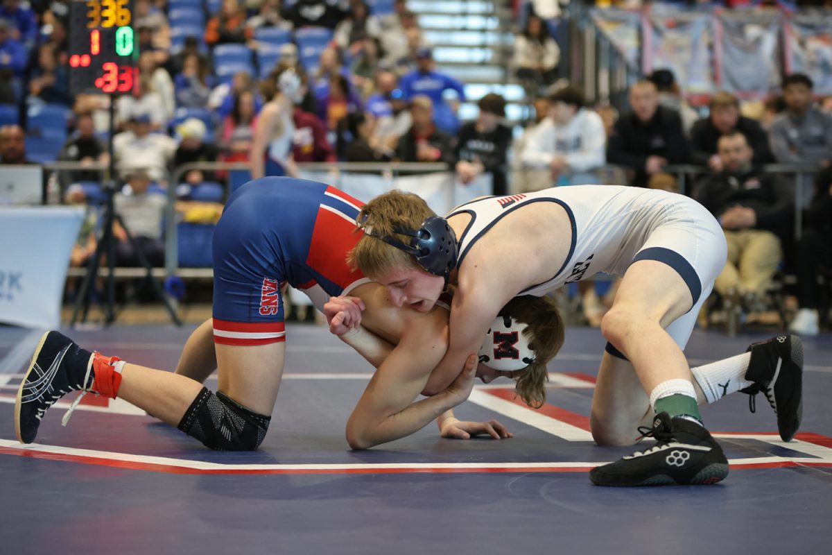 Arms interlocked, junior Jeredy Nilges battles it out with his opponent.