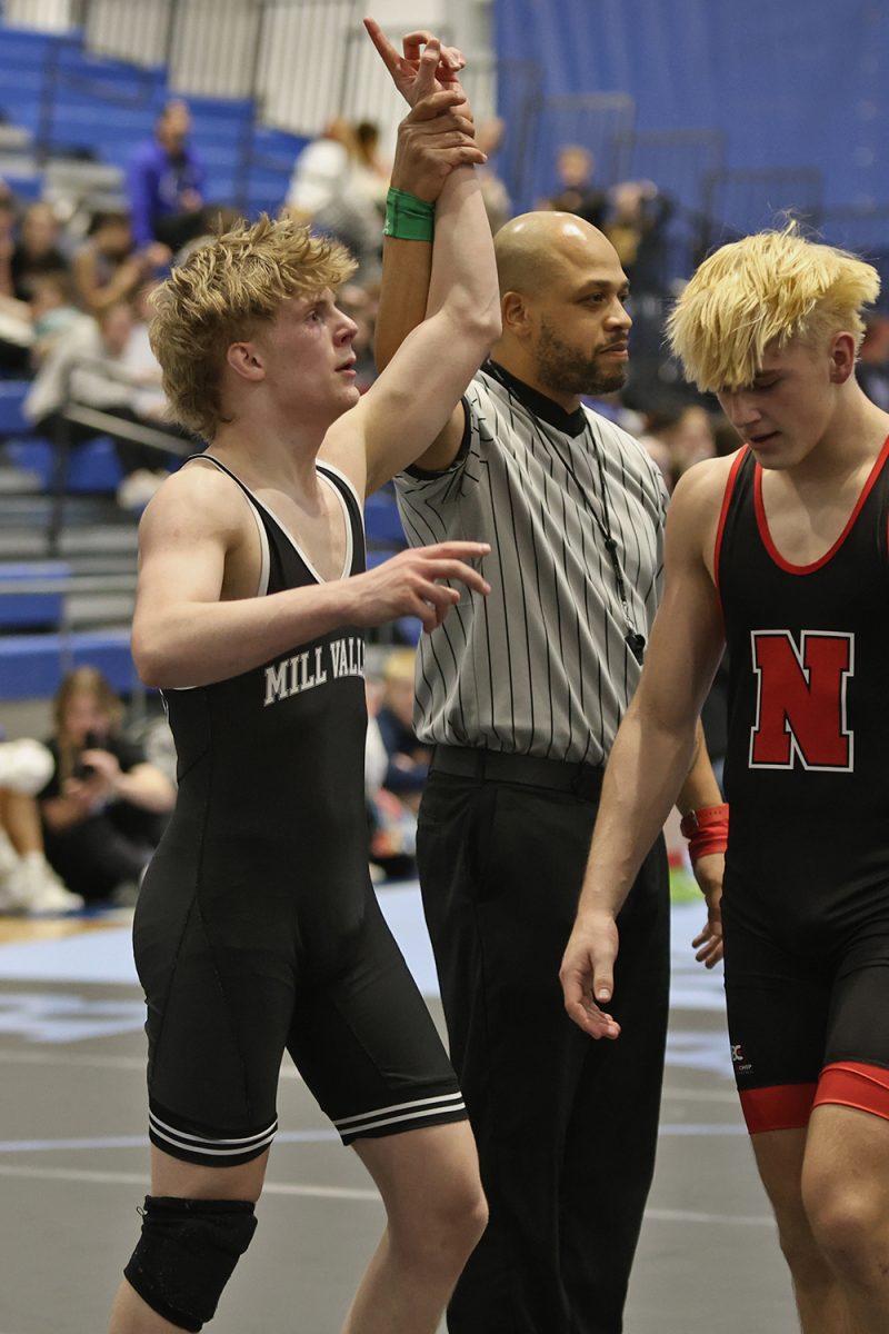 Hand raised in triumph, senior Colton Bendure holds up a finger after placing first at state.