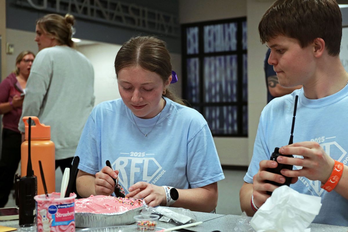 Relay chair senior Elly Hayes smiles while decorating the chair team cake for the cake decorating competition. 