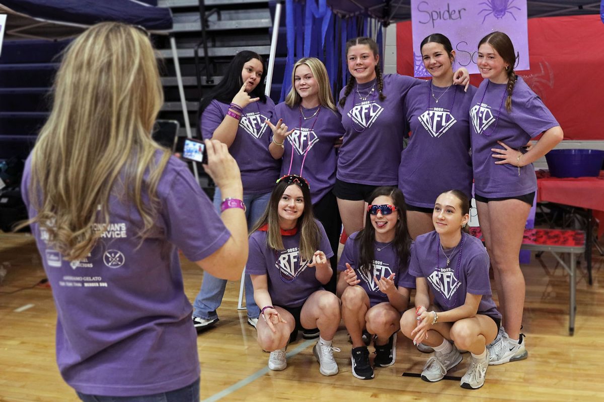In front of their booth, a Relay team poses for a photo together. 