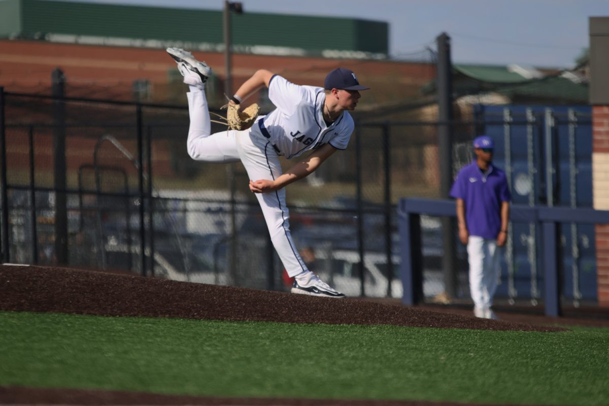Kicking his leg high, junior Brandon Neis delivers a pitch