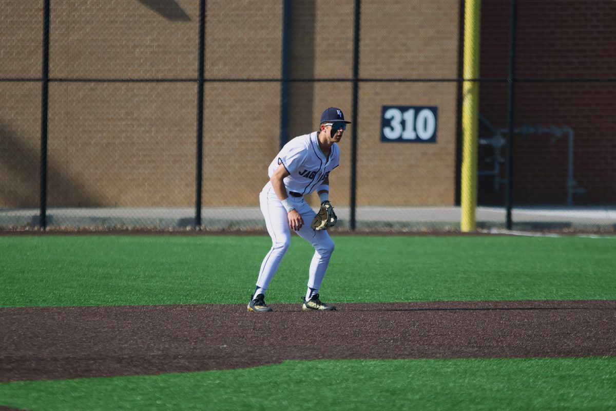 Doing his pre-pitch routine, junior Blake Jay gets down and ready