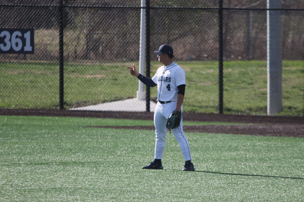 Pointing at his teammates, junior Jackson Lucht shows how many outs there are