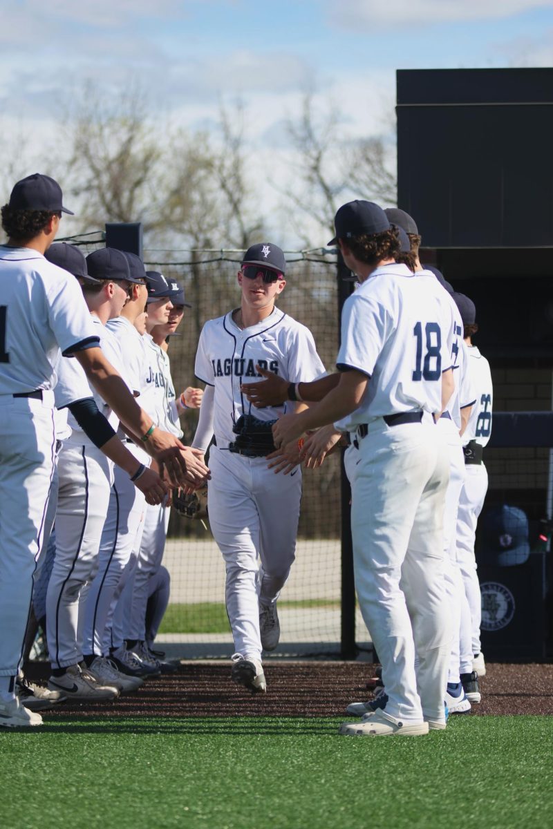 Senior Hudson Powers gets high-fives from his teammates as he runs by