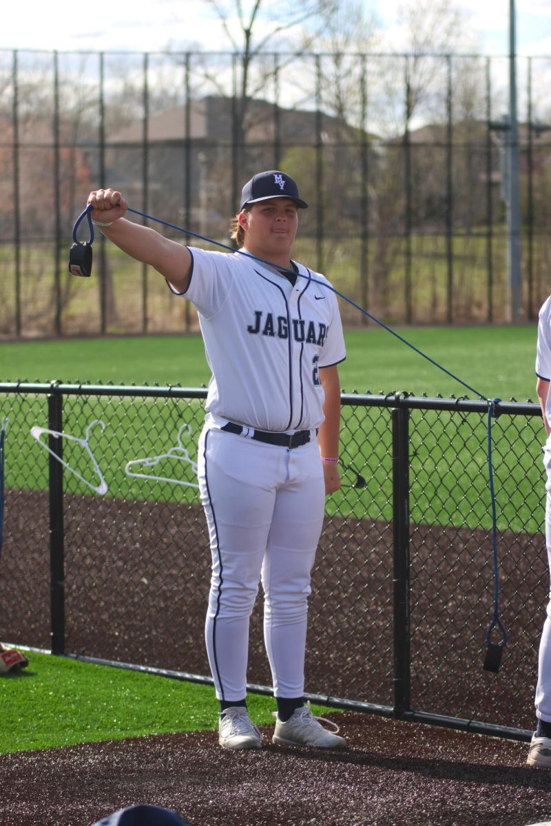 To stay warm in the bullpen, junior Ryan Gleason uses stretching bands