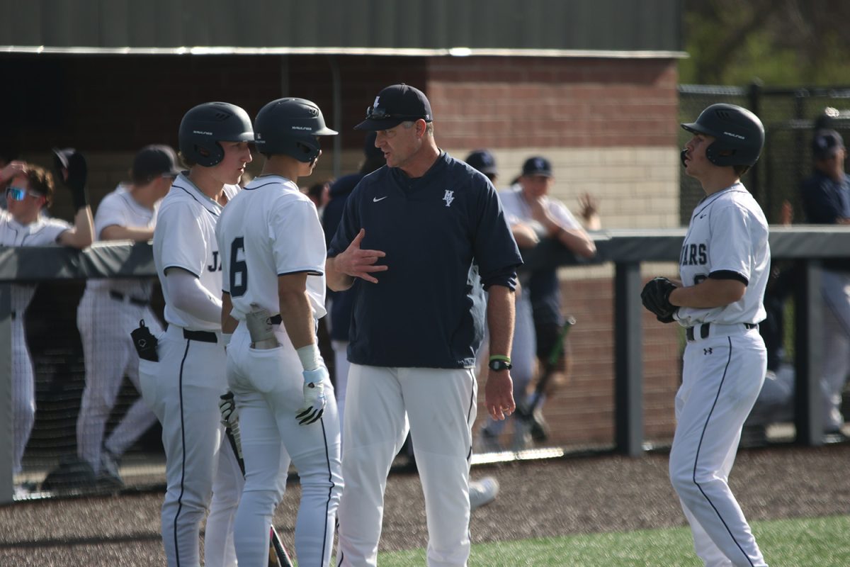 Coach Jeff Strickland talks through the game plan with his hitters