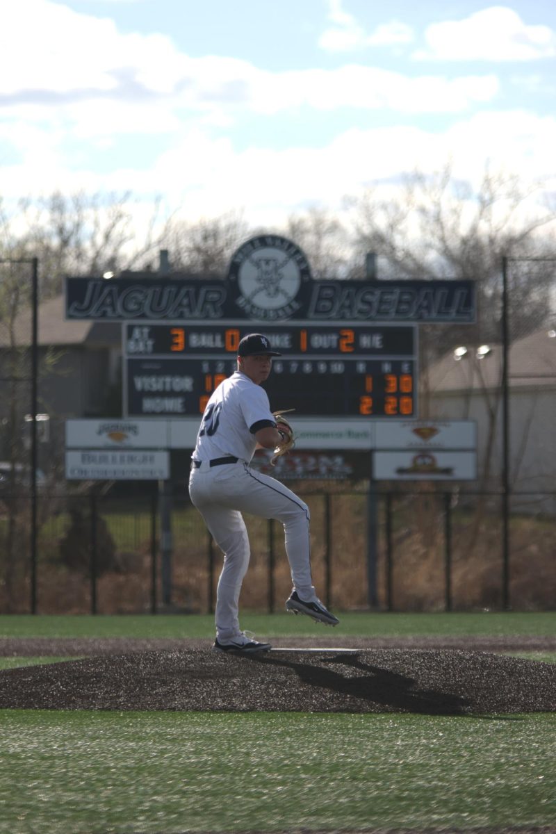 Junior Brandon Neis lifts his leg, ready to deliver a pitch