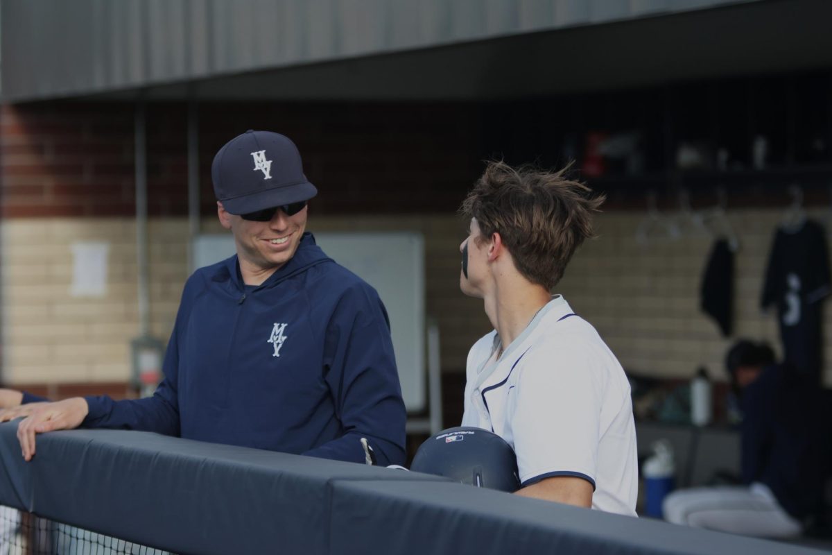 Coach Kurt Golubski and junior Blake Jay talk about the game plan in between innings