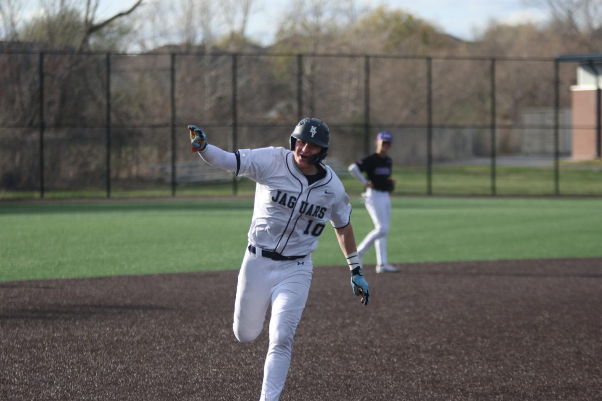 Rounding third after his home-run, junior Drew Yockey points to his dugout to celebrate