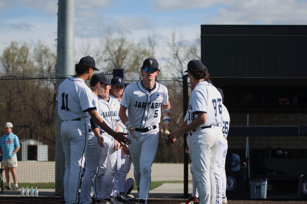 Senior Connor Bohon gets high-fives from his teammates as he runs to his position