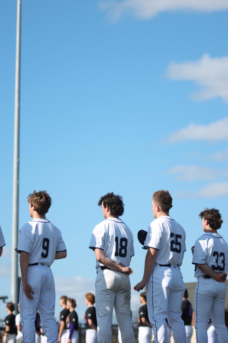 Players look to the flag while the national anthem plays