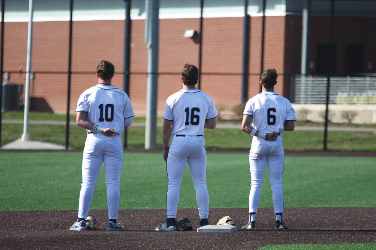 Juniors Drew Yockey, Beau Peterson and Blake Jay all look to the American flag during the anthem