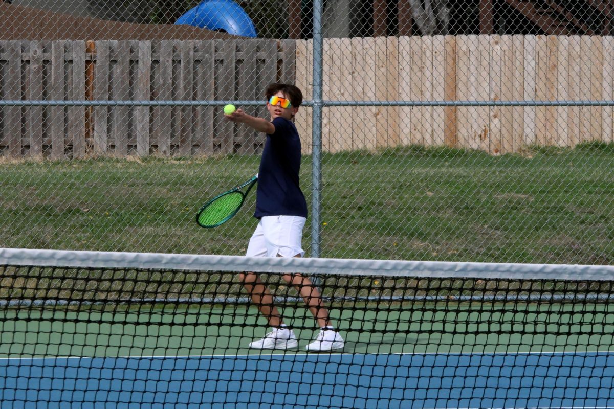 Freshman Spencer Reed serves a ball to his opponent.  