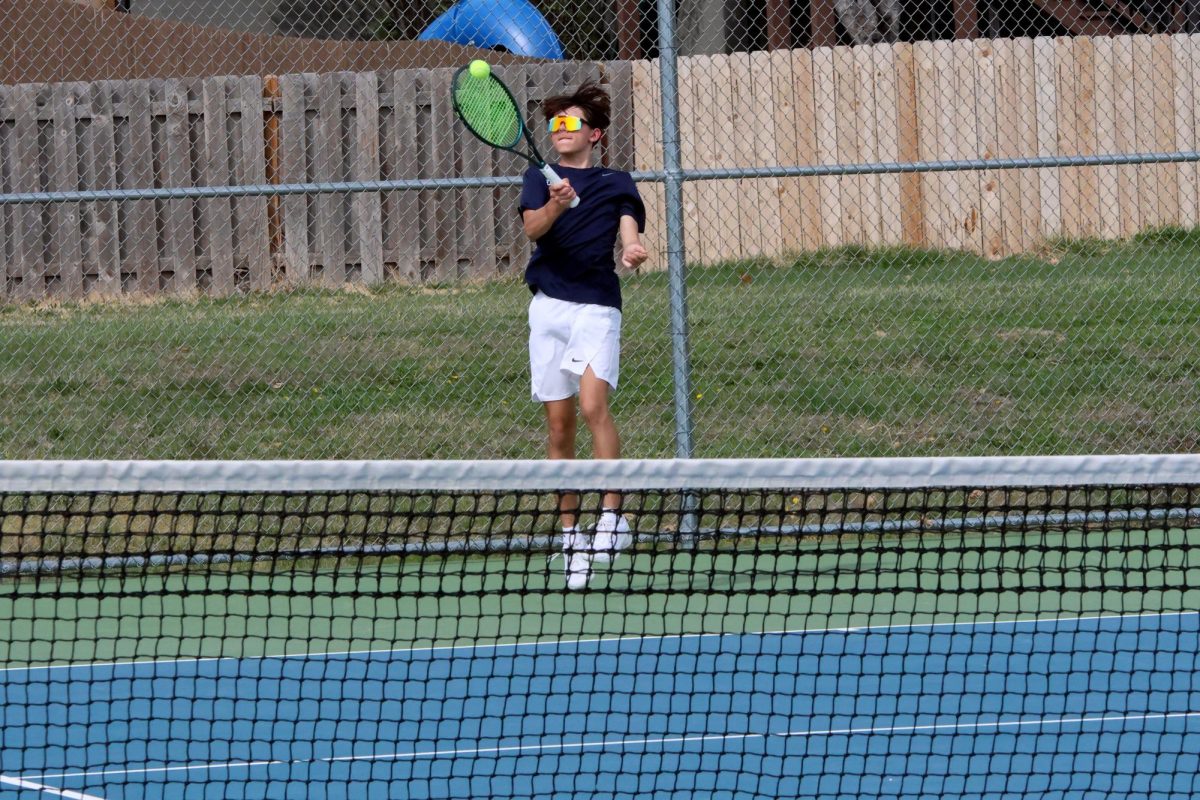 Freshman Spencer Reed hits a ball back to his opponent.   