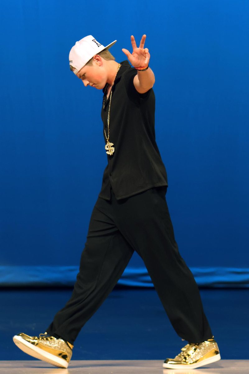 Gesturing to the audience, junior Elliot Fischer dresses as Bruno Mars for the idol portion of the pageant.