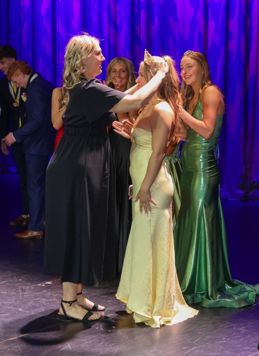 Grinning, prom chaperone Sarah Haub crowns the Prom Queen, senior Joey Nightingale.
