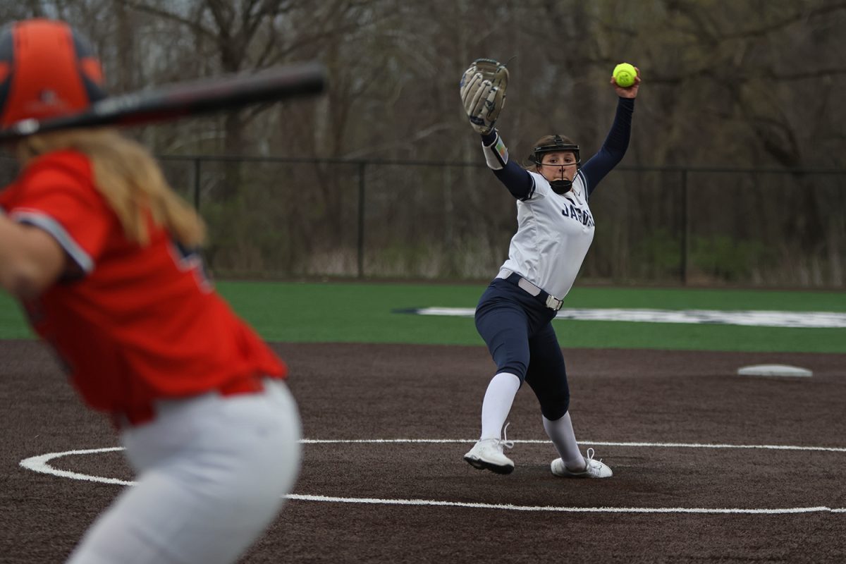 Striding out, sophomore Emma Hadley pitches the ball to the batter. 
