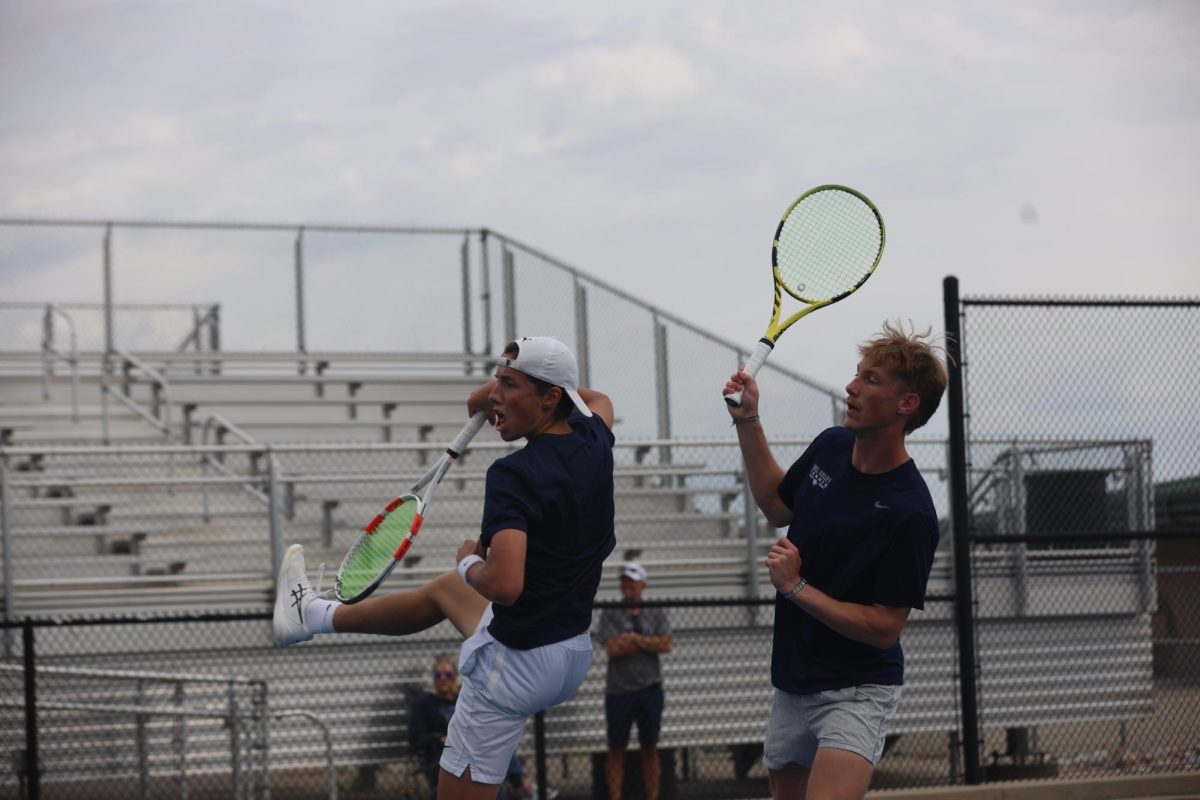 Playing doubles, sophomore Jace Hutchens and senior Cole Huffman both attempt to hit the tennis ball.