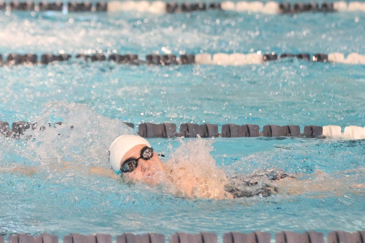 Water in her face, senior Evalyn Dill finishes her lap.
