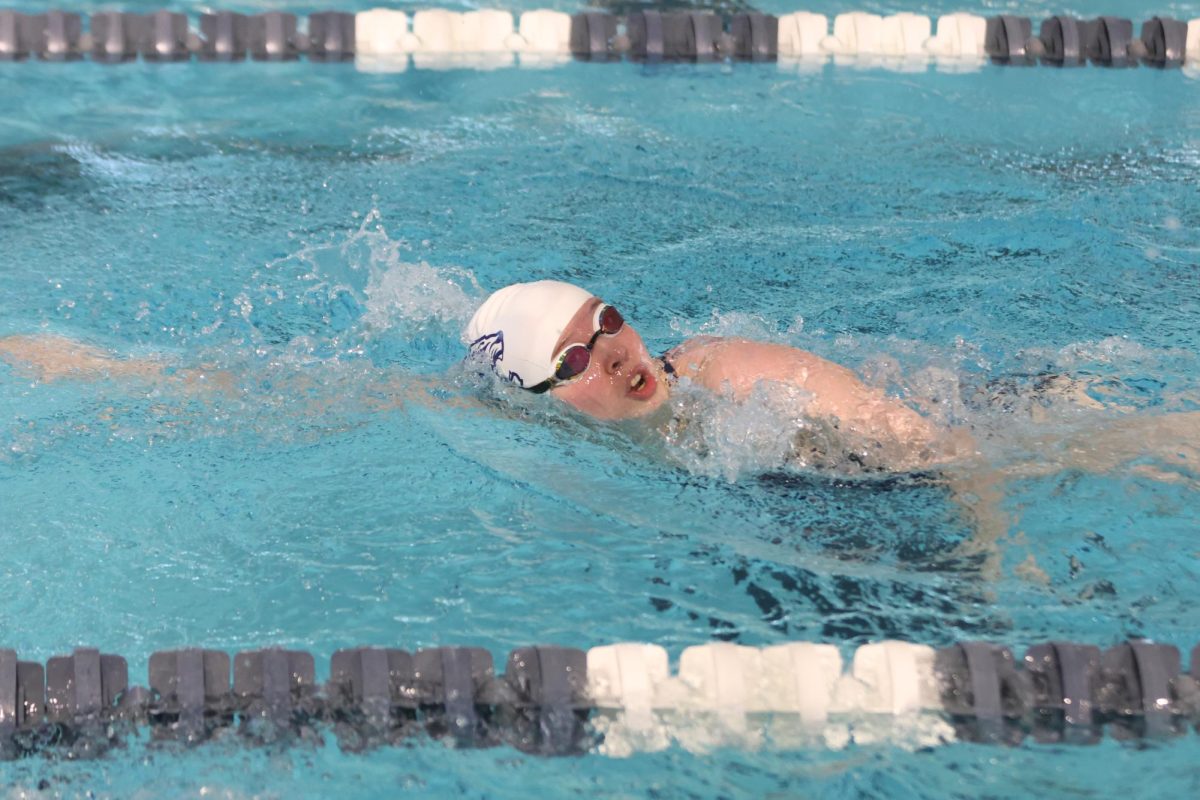 Reaching her arms forward, senior Cora Jones swims the 500Y freestyle.