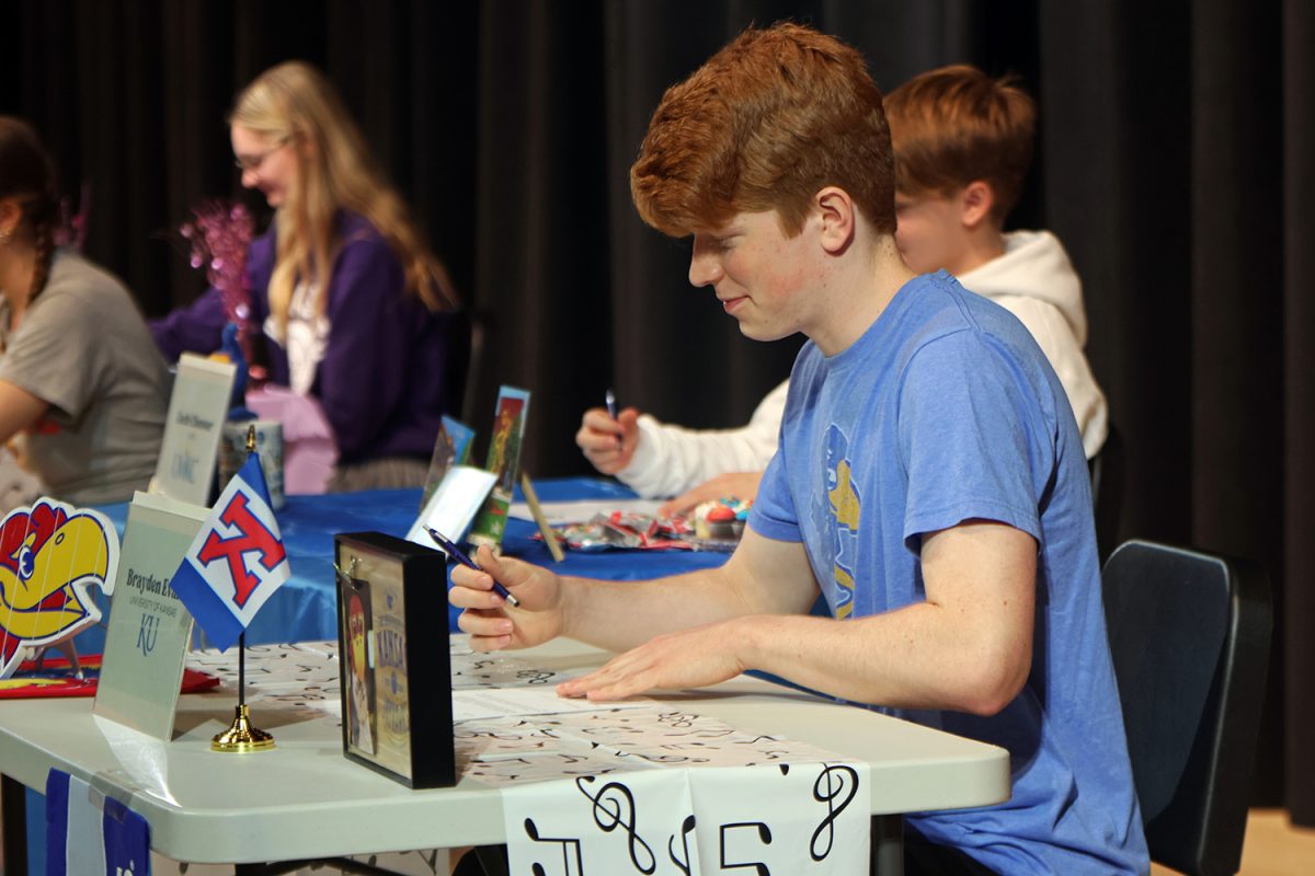 After the ceremony is completed, senior Brayden Evans signs for University of Kansas. 