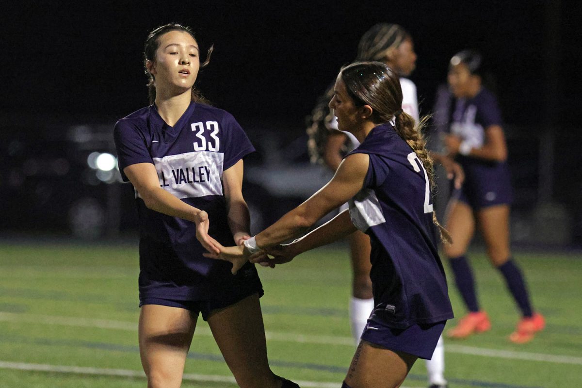 After the girls scored a goal, freshman Keanni Shang and sophomore Paige Frost celebrate with a low five. 