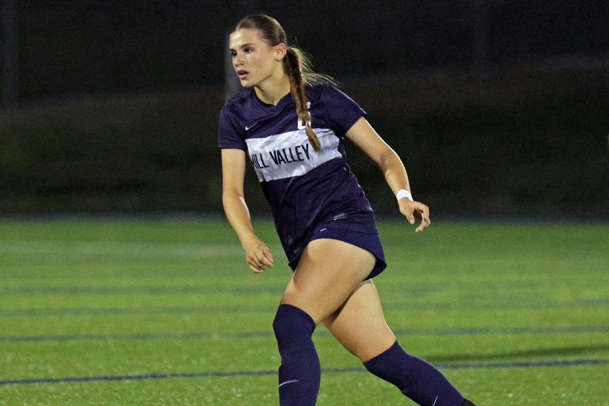Looking at her teammates, freshman Lyla Cinotto runs down the field. 