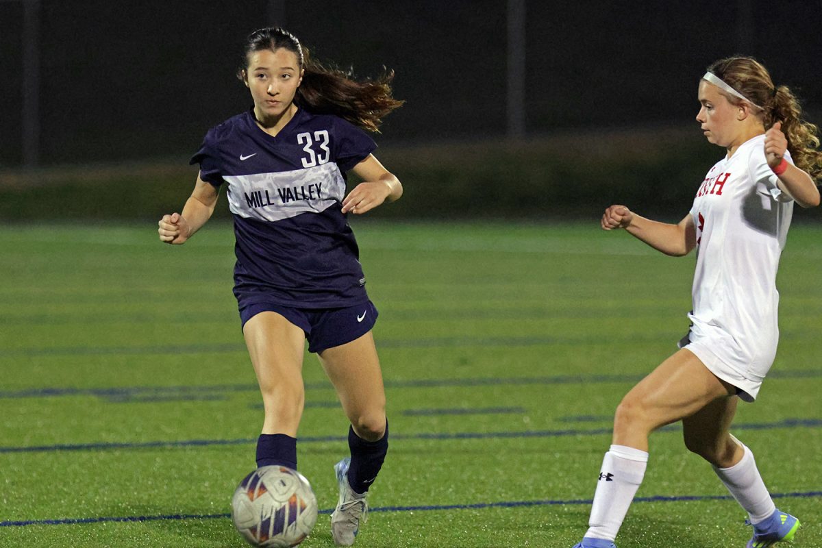 Ready to pass the ball, freshman Keanni Shang prepares to kick it away from an opponent. 