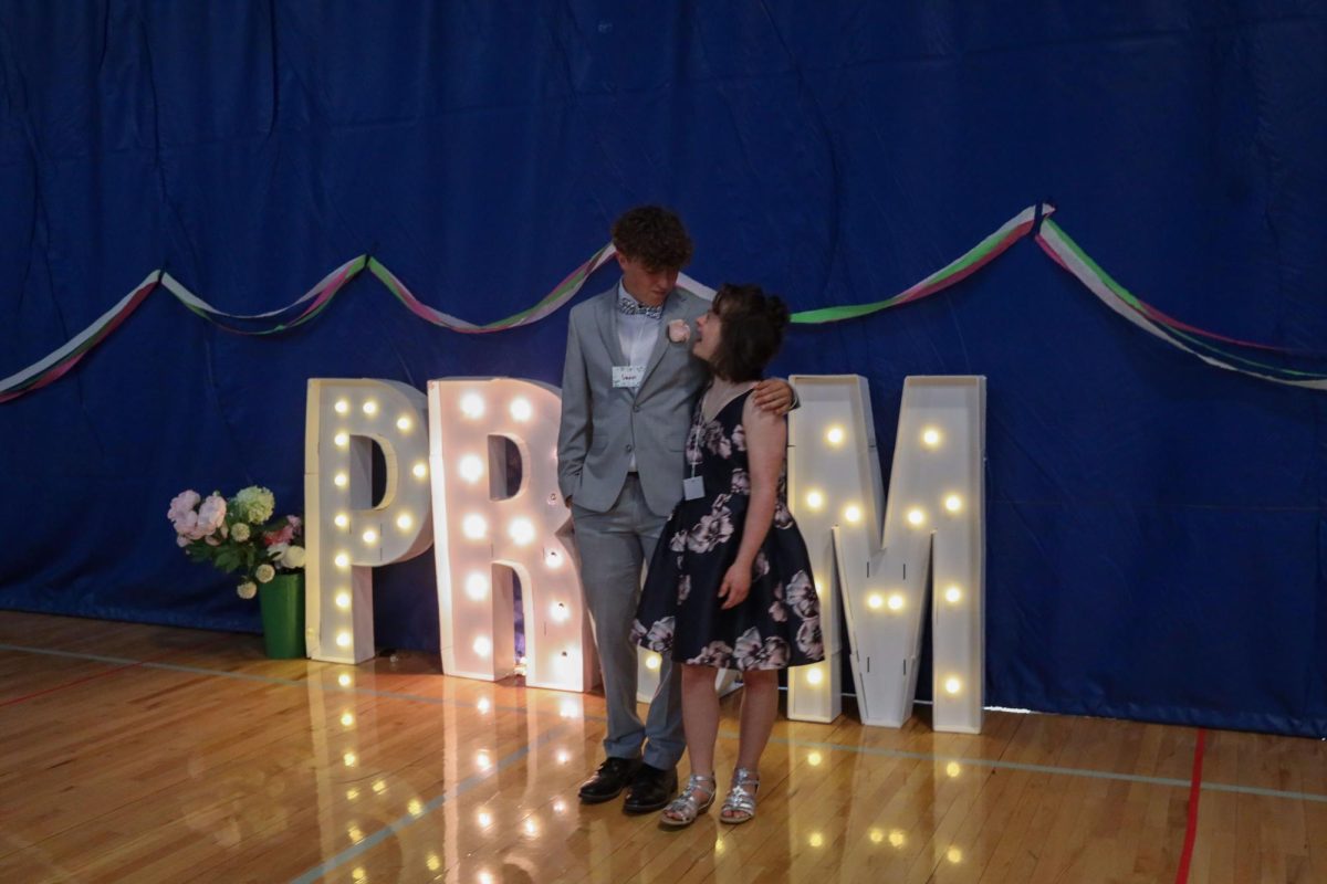 While taking a picture, Madi O. and junior Gavin Hurt laugh with each other.