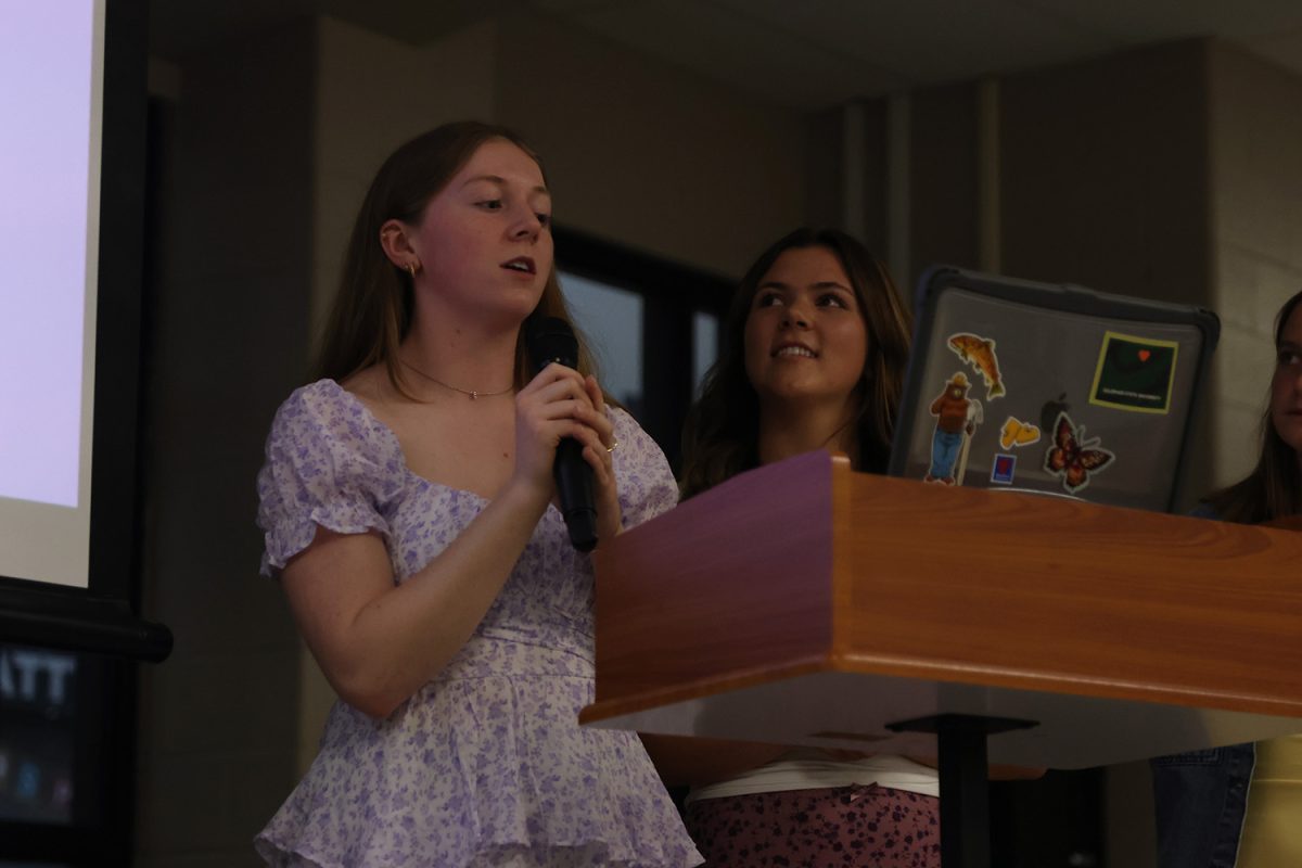 Speaking to the audience, seniors Elly Hayes and Brynn Shideler run the Relay For Life banquet. 