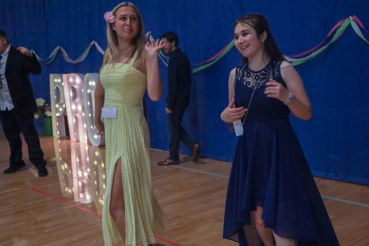 Dancing with junior Savannah Allen at prom, senior Maggie Wieland pumps the air with her hand.