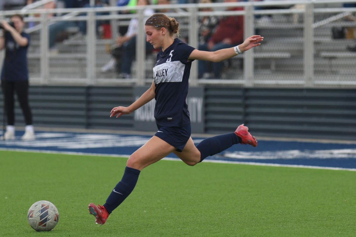 Looking at the ball, senior Kate Martin prepares to kick the ball towards the goal.

