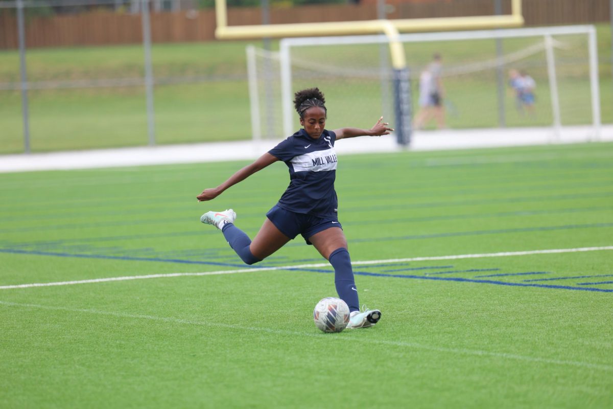 Arms out, sophomore Biti Hasabu kicks the ball down the field.
