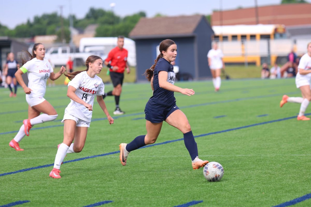Striding forward, senior Lauren Welch advances the ball.
