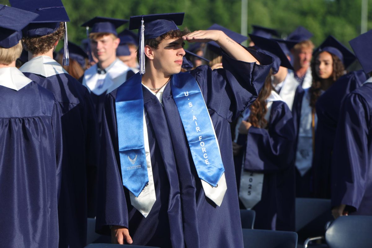 Looking towards the crowd, senior Korvin Brown stands on the field. 
