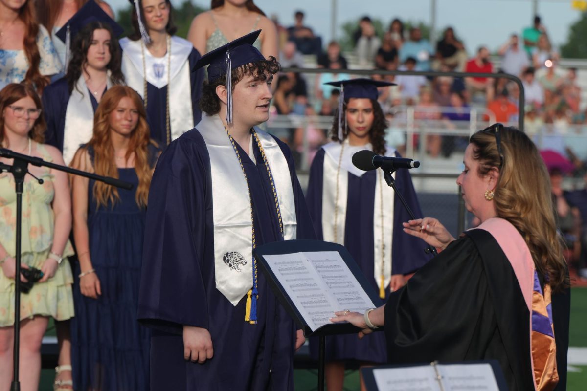 Following choir teacher Laura VanLeeuwen’s direction, senior Blake Gray starts off “A Million Dreams” by performing a solo.
