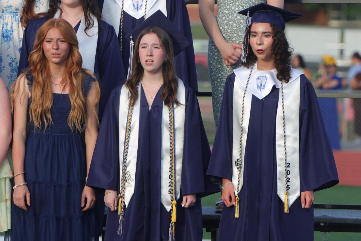 Singing out, sophomore Taylor Rude and seniors Reese Miller and Miranda Hakes sing at graduation.

