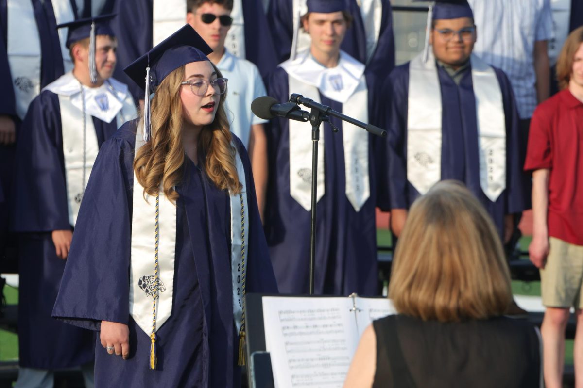 Standing, senior Lillian Schleicher sings a solo during “A Million Dreams”.
