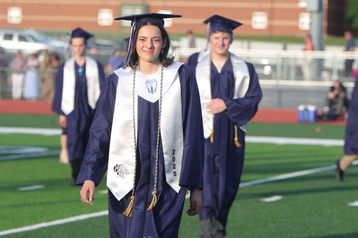 Smiling, senior Christina Baumgart walks from the choir risers back to her seat. 
