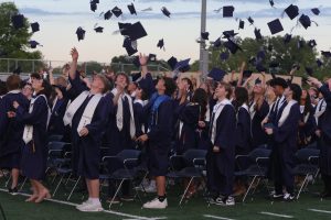 Looking up, the senior class throws their caps in the air.
