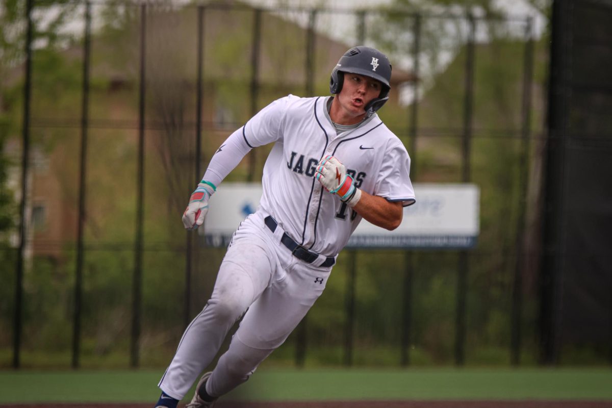 Rounding third, junior Drew Yockey heads home to score.
