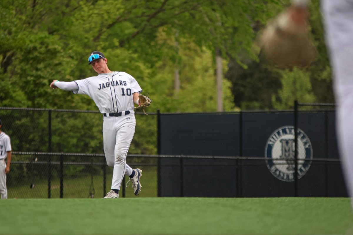 Bending his body, junior Drew Yockey throws over to first.